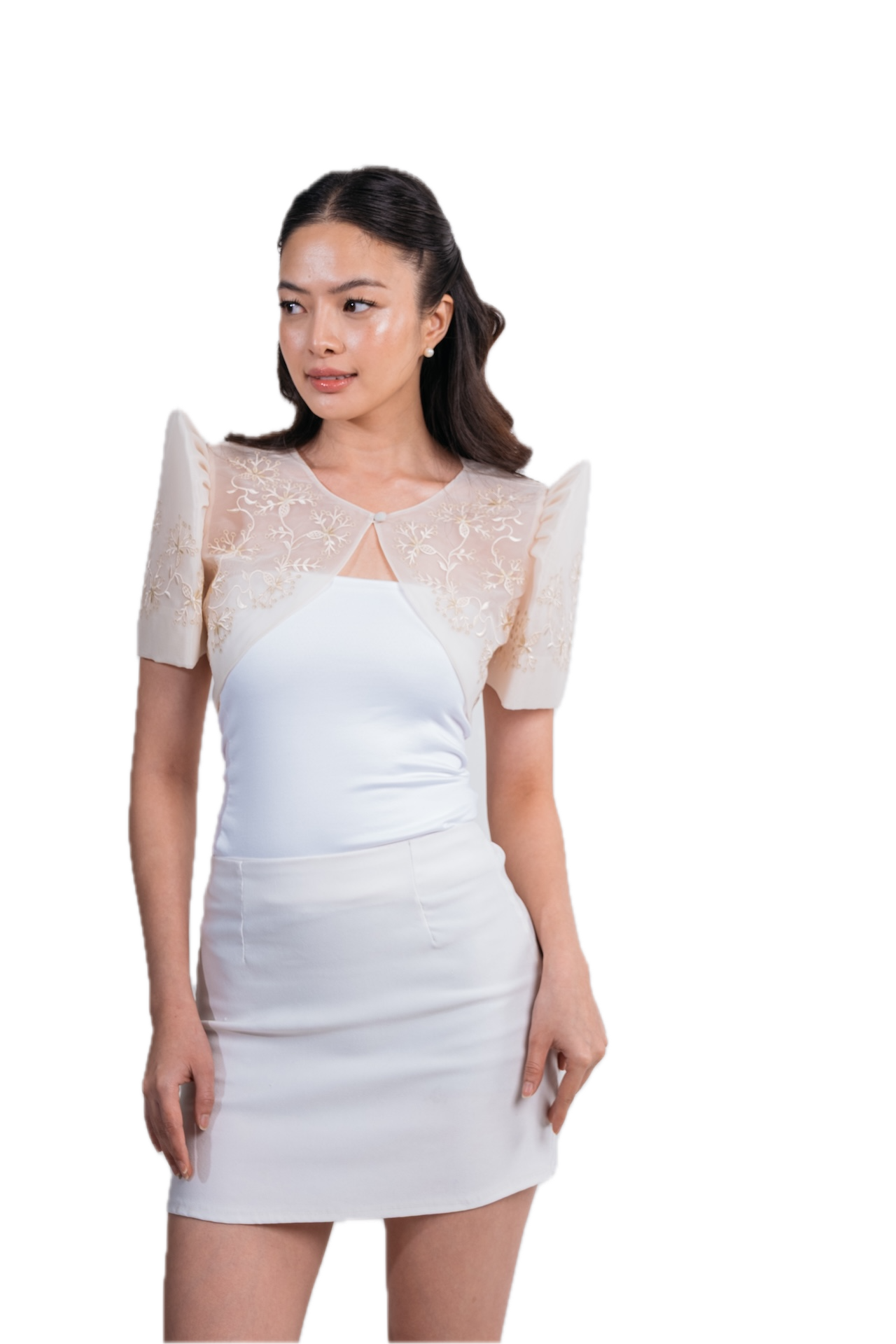 A woman modeling a white mini dress with sheer lace short sleeves and structured shoulders, photographed against a plain white background.